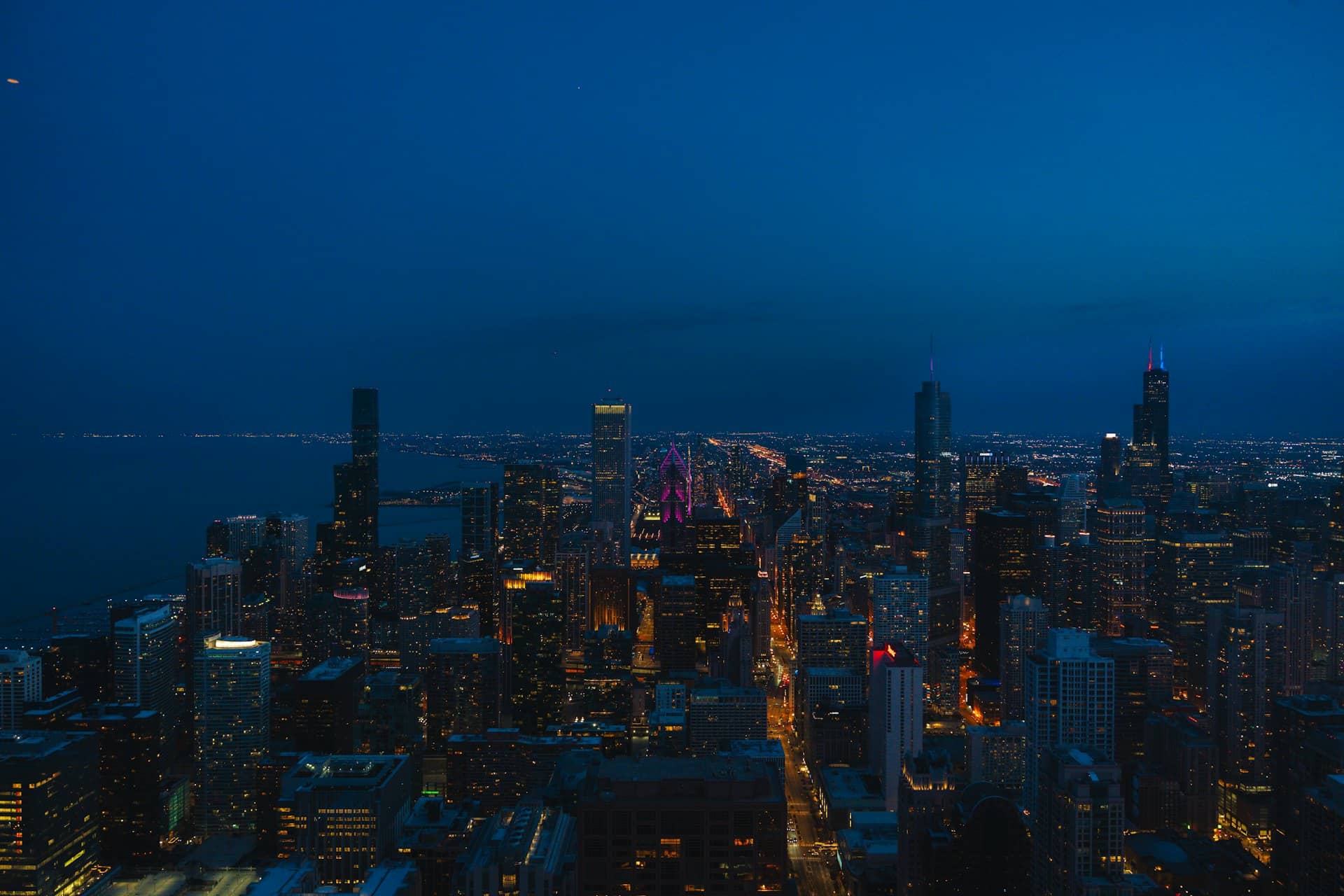 Chicago city skyline illuminated at night against a dark blue sky